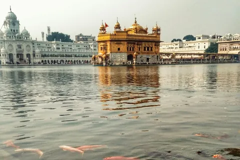 The Golden Temple across the sacred pool at Amritsar, with fish swimming in the foreground