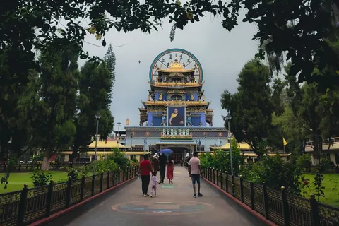 The Golden Temple at Namdroling Monastery near Kushalnagar in Coorg, seen through a flowering arch