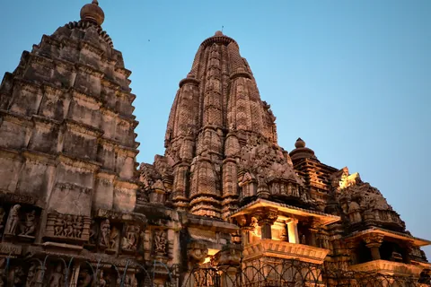 Carved temple towers at Khajuraho lit up at dusk