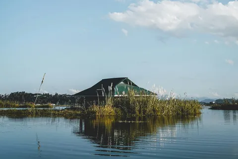 A hut among reeds on Loktak Lake, Manipur, under a wide blue sky