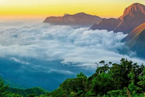 Sunrise over a sea of clouds between mountain ridges near Munnar