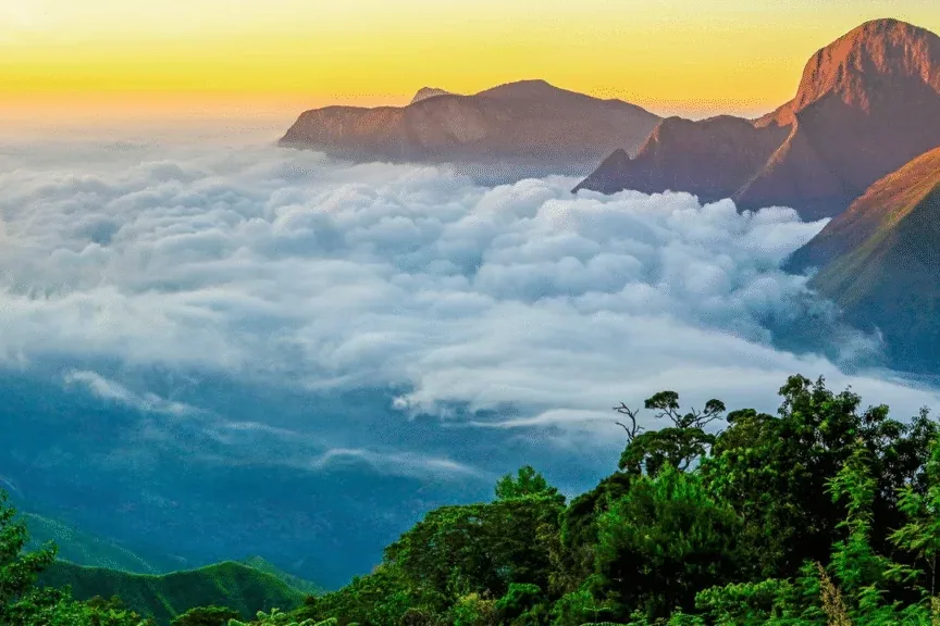 Sunrise over a sea of clouds between mountain ridges near Munnar