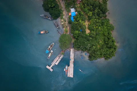 Aerial view of boats moored beside a jetty on a forested shoreline near Port Blair