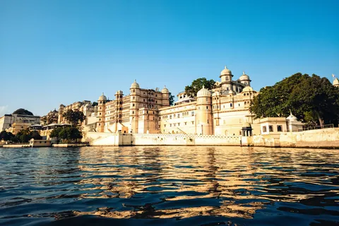 The City Palace rising above the waters of Lake Pichola in golden light, Udaipur